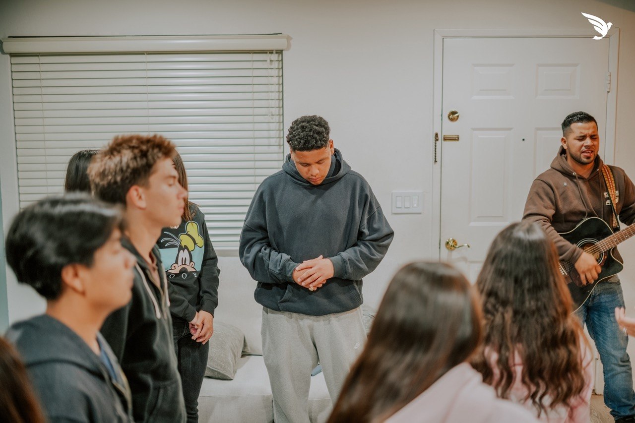 Jóvenes orando juntos en el grupo de hogar