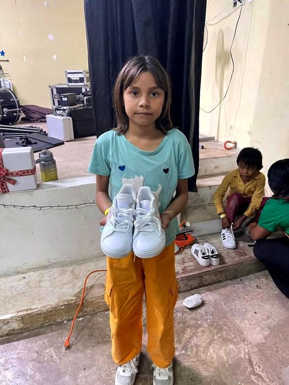 Niña recibiendo sus zapatos nuevos