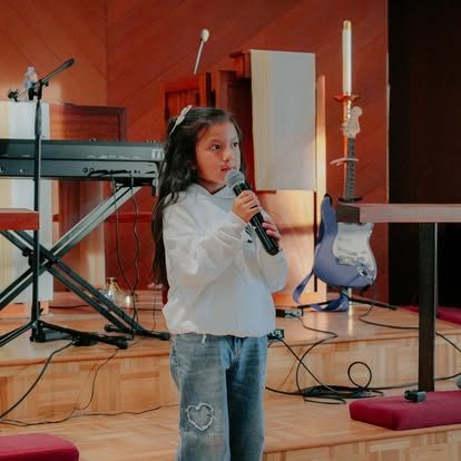 Niña cantando con el micrófono