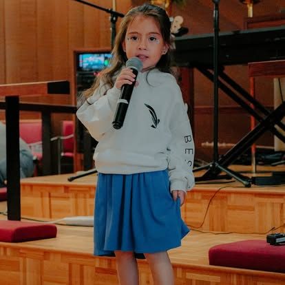 Niña cantando en el servicio