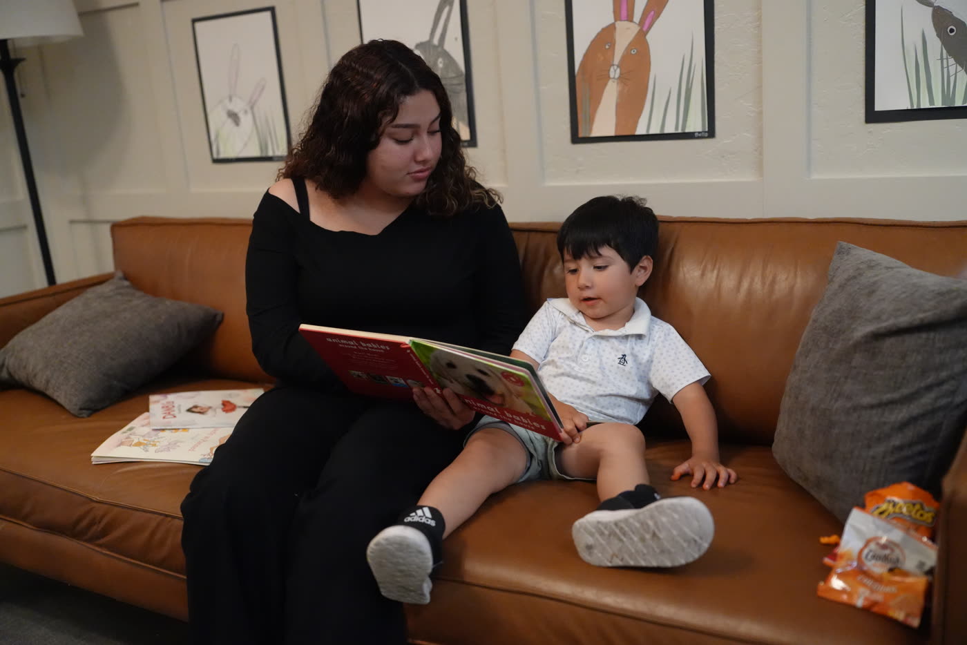 Maestra compartiendo un libro con un pequeño