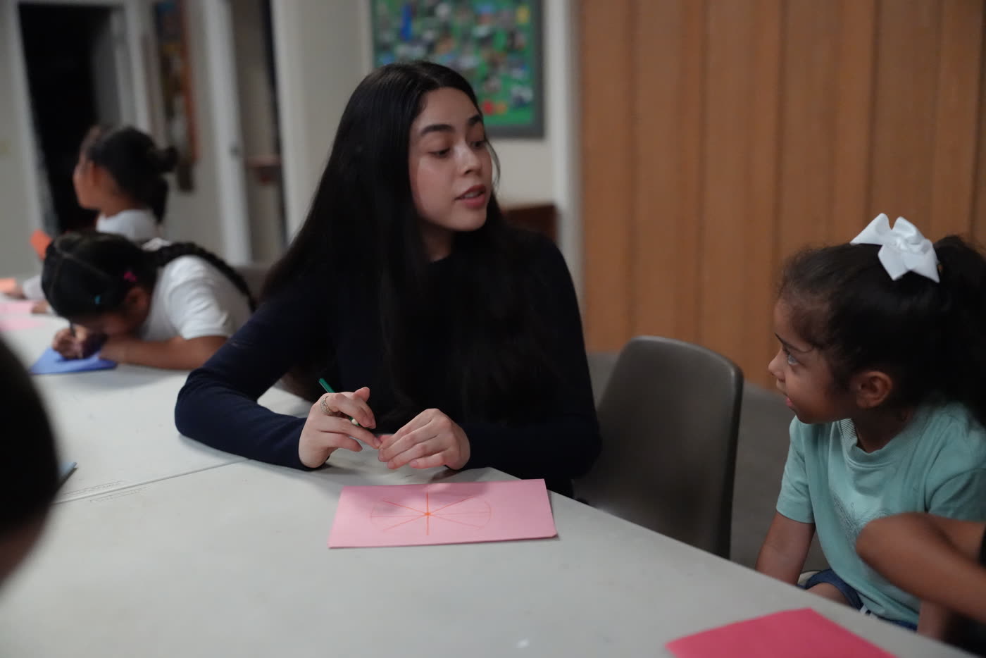 Maestra ayudando a las niñas con su actividad